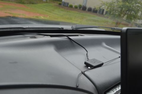 1992 Ford Bronco - Interior view of a vehicle's dashboard with a mounted GPS device and visible exterior through the windshield.