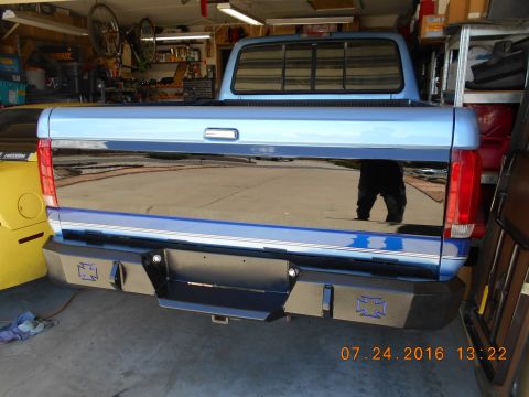 1996 Ford F-250 - Rear view of a blue 1996 Ford F-250 pickup truck a custom aftermarket bumper with cross emblems.