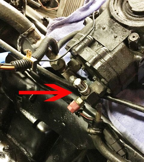 1978 Ford Bronco - A red arrow highlights a fitting on a vehicle's power steering component, likely for fluid or pressure.
