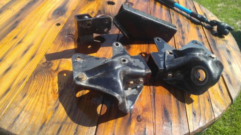 1991 Ford Bronco - Several black suspension components are laid out on a wooden surface.