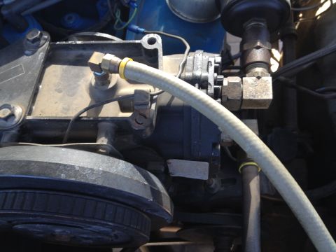 1979 Ford Bronco - This image shows a close-up view of a vehicle's engine compartment, focusing on a pump and associated plumbing.