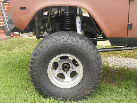1972 Ford Bronco - Close-up of the suspension and wheel of a modified off-road vehicle.