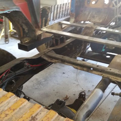 1979 Ford Bronco - The frame and undercarriage of a vehicle are visible, with suspension and exhaust systems in place, suggesting ongoing work.