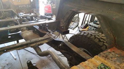 1979 Ford Bronco - Vehicle frame and suspension components are visible during a repair process in a workshop.