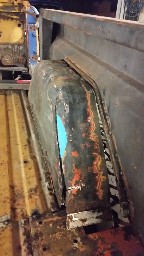 1979 Ford Bronco - The interior of a vehicle's wheel well shows significant rust and damage to the fuel tank.