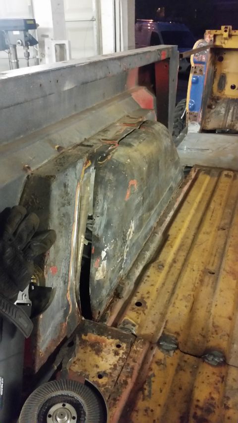 1979 Ford Bronco - Interior view of a damaged vehicle, likely a Ford Bronco, with significant rust and a visible wheel well. Another vehicle is present in the…