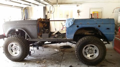 1979 Ford Bronco - This Ford Bronco is in a garage, stripped down and ready for restoration work. It's sitting on a lift with large tires.