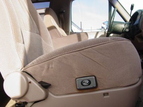 1992 Ford Bronco - Close-up of the tan cloth interior, highlighting the power seat controls and seat fabric.