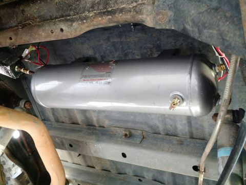 1992 Ford Bronco - An air tank is mounted beneath the vehicle's frame, connected to electrical wiring and air lines.
