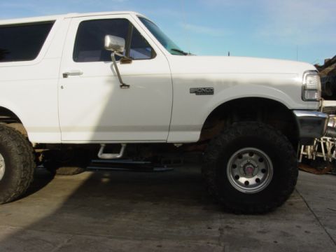 1992 Ford Bronco - Side view of a white 1992 Ford Bronco with aftermarket wheels and tires.