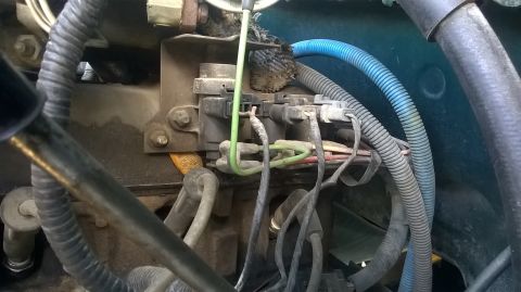 1996 Ford F-150 - Close-up view of a vehicle's engine wiring harness, showing various electrical components and tubing.