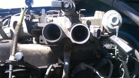 1996 Ford F-150 - Close-up view of an engine's throttle body assembly.
