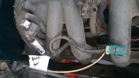 1996 Ford F-150 - Close-up of an engine's intake manifold, showing sensors and wiring. A handwritten note is visible.