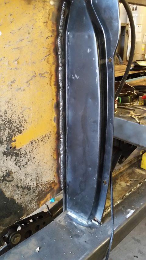 1979 Ford Bronco - A close-up view shows a freshly welded seam joining a black metal panel to a yellow, weathered surface, likely part of a vehicle's body or…