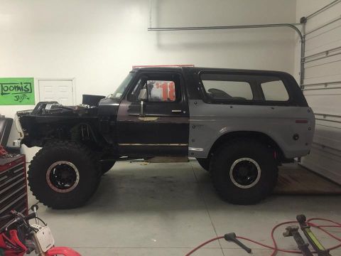 1979 Ford Bronco - A heavily modified Ford Bronco is shown in a garage setting. The vehicle has large off-road tires, a lifted suspension, and appears to be u…