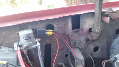 1981 Ford Bronco - A close-up view of electrical components mounted to the engine bay of a red vehicle. Visible parts include a gray solenoid labeled "SELECT"…
