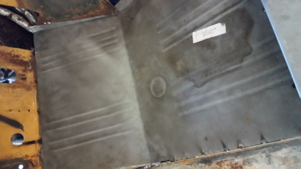 Interior floor pan of a vintage vehicle with a white label.