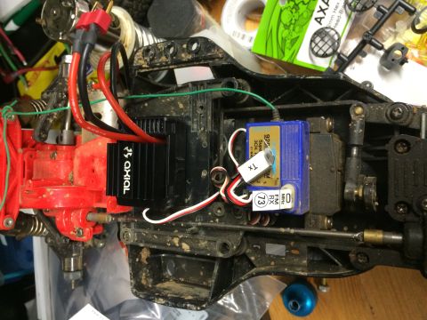 1989 Ford Bronco - A close-up, overhead view of the chassis of a remote-controlled car, showing the electronic speed controller, receiver, and servo motor.