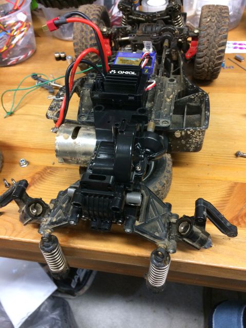 1989 Ford Bronco - A close-up, overhead view of the chassis and drivetrain of an RC car, showing the motor, electronic speed controller, and suspension compon…