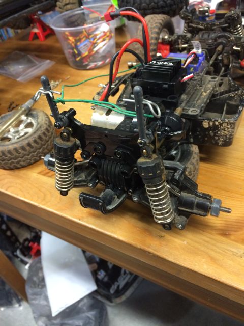 1989 Ford Bronco - A close-up view of the rear suspension and electronics of a dirty remote-controlled car, likely undergoing maintenance or modification on a…