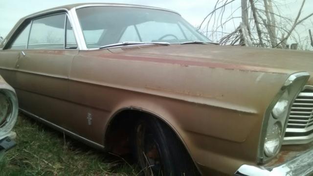 Weathered tan 1965 Ford LTD coupe, side view, parked outdoors.