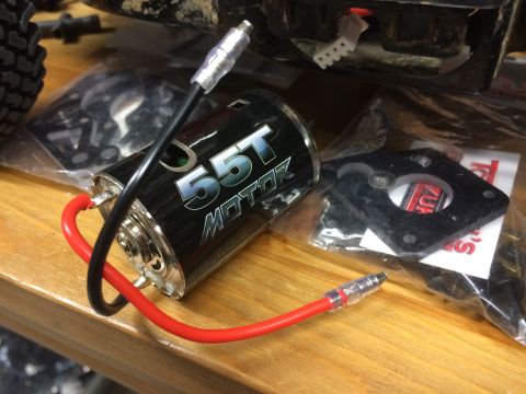 1989 Ford Bronco - A 55T electric motor with red and black wires is shown on a wooden surface, with parts and packaging in the background.