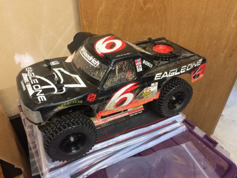 1989 Ford Bronco - A black remote-controlled monster truck with red and white "6" decals is shown from a 3/4 front angle. The truck is covered in dirt and has…