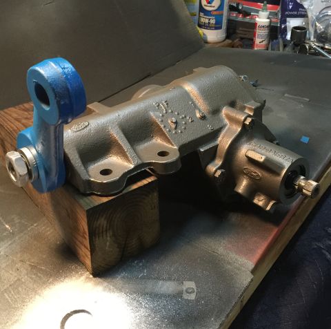 1978 Ford Bronco - A gray Ford power steering gearbox is mounted on a wooden block, with a blue painted tie rod end assembly visible on the left. The gearbox…