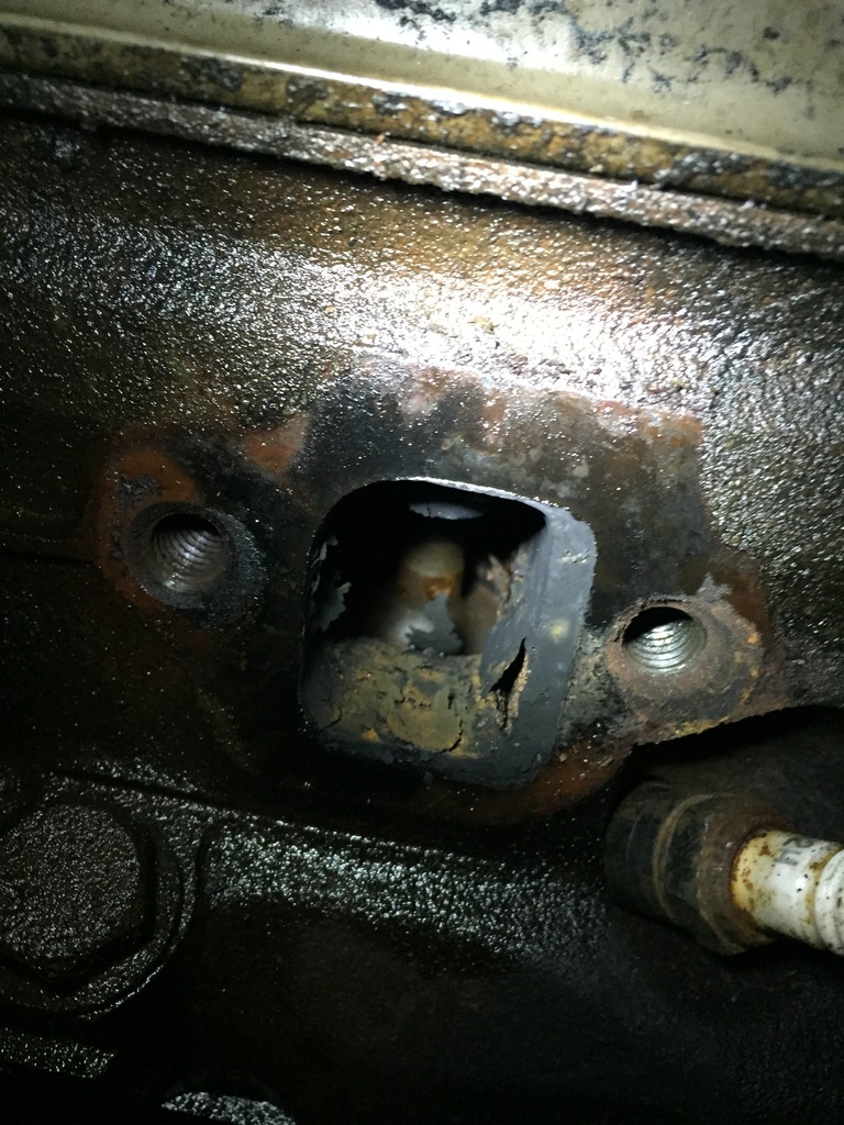 Engine block rear with worn oil-soaked rubber freeze plug or seal opening