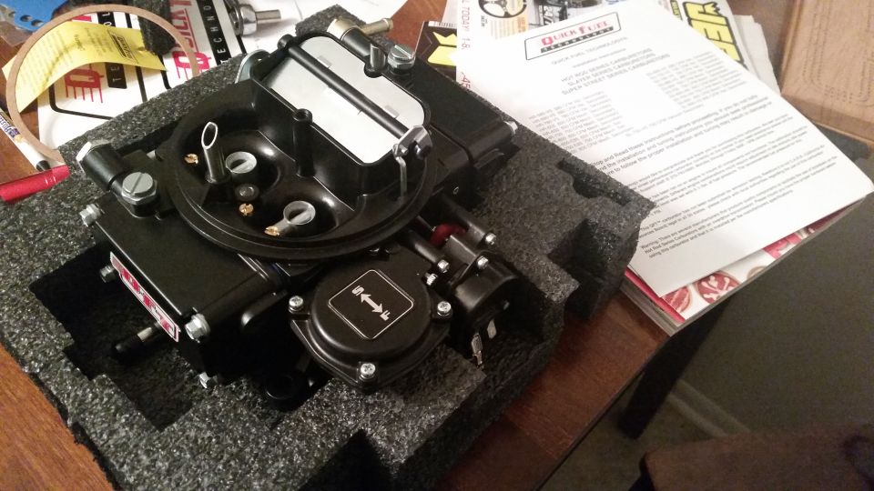 New black Quick Fuel Technology carburetor in foam packaging with instruction manual.