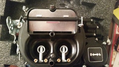 1981 Ford Bronco - A close-up, overhead view of a black Holley carburetor with a silver lid. The carburetor is sitting in a black foam-lined box.