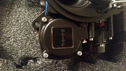 1981 Ford Bronco - A close-up view shows a black component with a square inset that has an "S" above a double-headed arrow and an "F" below it. The component…