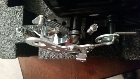 1981 Ford Bronco - A close-up view shows the intricate mechanical linkage of a vehicle's throttle body assembly, featuring springs, levers, and bolts against…