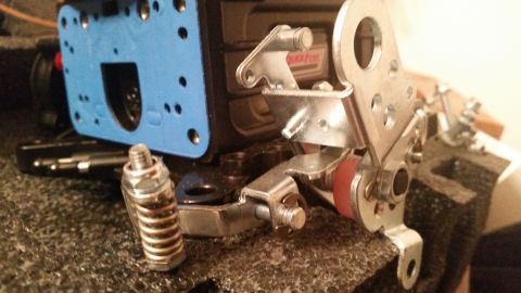 1981 Ford Bronco - A close-up view of mechanical linkage and a blue component, possibly part of a vehicle's engine or transmission system.