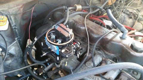 1981 Ford Bronco - A close-up view of a newly installed aftermarket carburetor on a V8 engine. The engine bay shows various hoses, wires, and the distributor…
