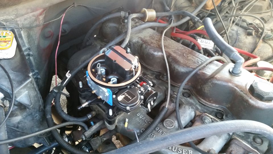 Aftermarket carburetor installed on a V8 engine.