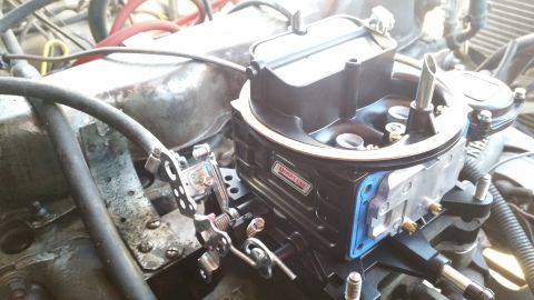 1981 Ford Bronco - A close-up view of a newly installed Quick Fuel Technology carburetor on a vehicle engine. The carburetor is black with a blue gasket visib…