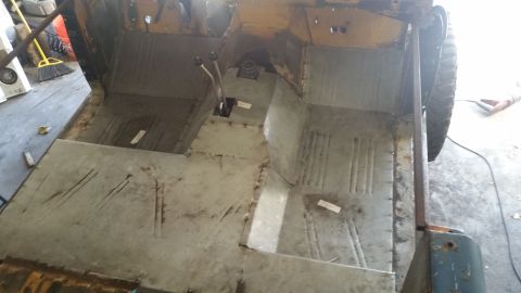 1979 Ford Bronco - The interior of a vehicle undergoing restoration shows the bare metal floor pans and transmission tunnel. Two gear shifters are visible in…