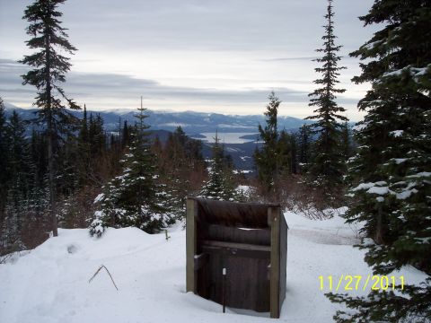 2004 Arctic Cat King Cat 900 - Winter scene in the mountains with a lake visible in the distance and a wooden structure in the snow.