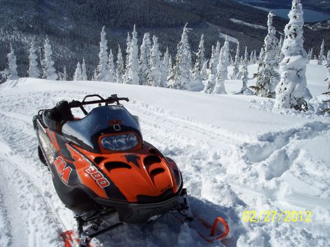 2004 Arctic Cat King Cat 900 - A snowmobile sits ready for a ride in a winter mountain landscape.