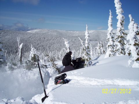 2004 Arctic Cat King Cat 900 - A person rests in a snowy mountain landscape with a date stamp of 02/27/2012.