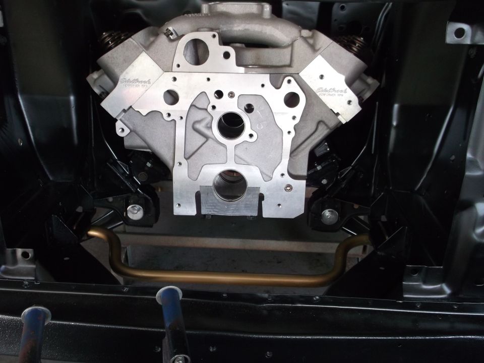 Overhead view of a silver V8 engine block in a black engine bay.