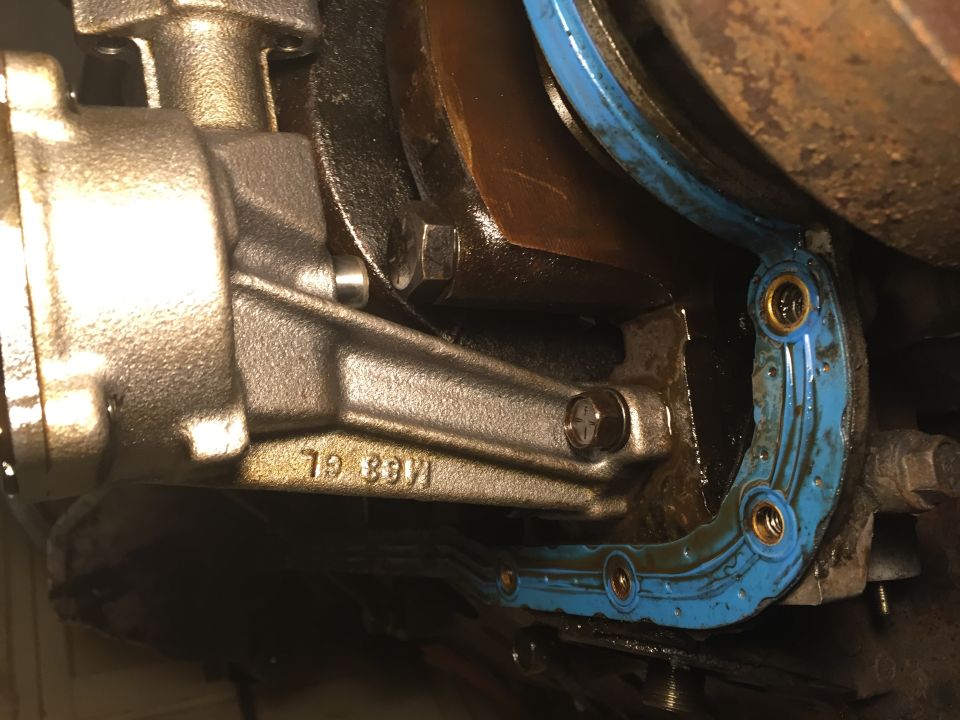 Blue gasket on differential housing with visible oil