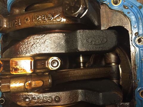 1989 Ford Bronco - Close-up of engine internals, showing a Ford logo on the crankshaft and part numbers.