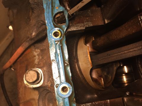 1989 Ford Bronco - Close-up of an engine gasket with visible sealant and grommets, part of an engine assembly.