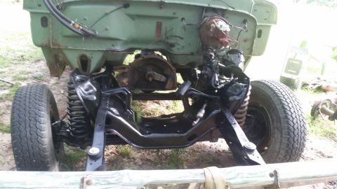 1978 Ford Bronco - The front end of a vehicle is shown with its frame and suspension components exposed, suggesting a restoration project.