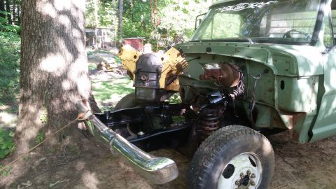 Green truck with engine removed, front view. Watermark 'SUPERMOTORS'