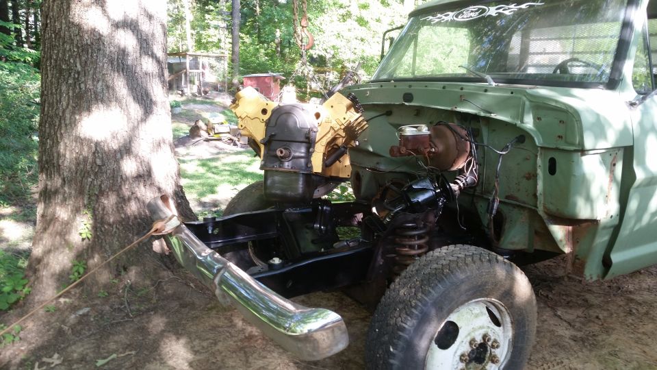 Green truck with engine removed, front view. Watermark 'SUPERMOTORS'