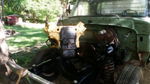 Truck with engine removed, showing the engine bay and frame. Some parts are painted yellow and black