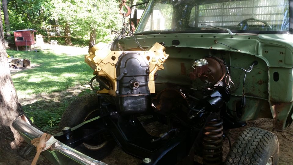 Truck with engine removed, showing the engine bay and frame. Some parts are painted yellow and black
